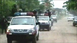 Police vehicles head to the scene of the killings in Honduras