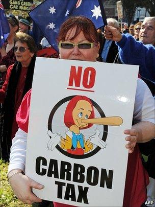 A woman holds a placard depicting Australian Prime Minister Julia Gillard as Pinocchio during the "No Carbon Tax - Election Now" rally through Sydney (31 July)