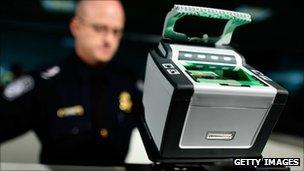 US Customs and Border Protection officer stands behind the digital fingerprint machine he uses at Dulles International Airport