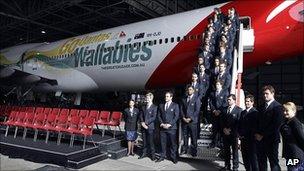 Members of the newly named 30-man squad for next month's rugby World Cup stand on the stairs of a Qantas jet in Sydney