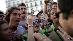 Pilgrims (left) argue with austerity protesters on Sol Square in Madrid, 17 August