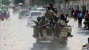 Somali army soldiers ride in the back of a pick up truck as they make their way to the northern part of Mogadishu on 17 August 2011