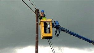 engineer in cherry picker repairing phone line