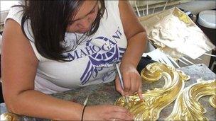 Mahogany Carnival Design worker trimming part of headdress