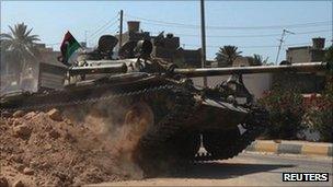 A Libyan rebel tank drives through Maya, 21 August