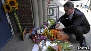 A constituent lights a candle in memory of Jack Layton on Monday