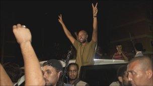 Col Gaddafi's son, Saif al-Islam, waves to troops loyal to his father in Tripoli, 22 August