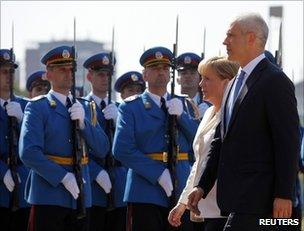 Serbian President Boris Tadic (R) escorts German Chancellor Angela Merkel past an honour guard in Belgrade, 23 August