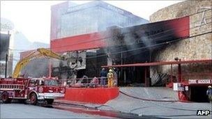 Smoke billows from the Monterrey's Casino Royale as firefighters battle flames, Mexico, 25 August 2011