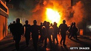 Riot police in front of a burning building in Croydon, South London