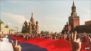 AUGUST 22: People holding a huge Russian flag flash victory signs on Red Square in Moscow as they celebrate the failure of a hardline communist-led coup which nearly toppled Soviet President Mikhail Gorbachev. Date: 22 August 1991