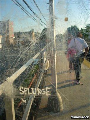 Man walks past a scratched and vandalised shelter on a train platform