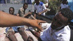 Two men accused of being mercenaries fighting for Muammar Gaddafi sit in a rebel vehicle in Tripoli