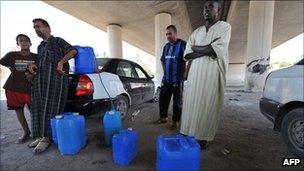 People buy petrol under a motorway bridge in the Libyan capital Tripoli.