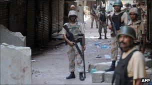Pakistani paramilitary soldiers cordon off a street during house to house search operations against criminals in a troubled area of Karachi on August 28, 2011.