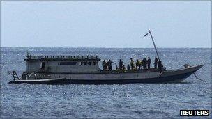 An Australian Navy boat comes alongside a boat carrying 50 asylum seekers after it arrived at Flying Fish Cove on Christmas Island, about 2,600 km (1,615 miles) north-west of Perth, 7 August 2011