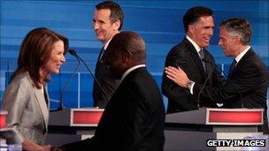 Republican presidential hopefuls shake hands at a debate in Iowa