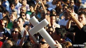 A man holds up a white cross during a protest against violence in Monterrey on 28 August 2011