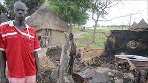 Kuol Bol, from the Lou Nuer ethnic group, next to the remains of huts destroyed in the attack on Pieri by Murle fighters in August