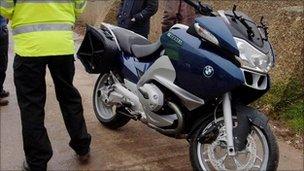 Policeman stood next to motorbike