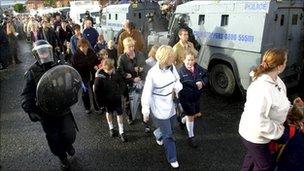 children walk to school past police lines during holy cross dispute