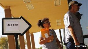 A man and woman enter a job fair in Phoenix, Arizona, on 30 August 2011