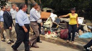 New Jersey Gov. Chris Christie looks on as President Barack Obama greets a woman as he visits areas damaged by Hurricane Irene, 4 Sept. 2011, in Wayne, NJ