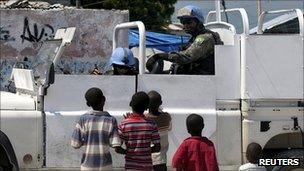 Brazilian peacekeepers in a a vehicle talk to Haitian children in Port-au-Prince