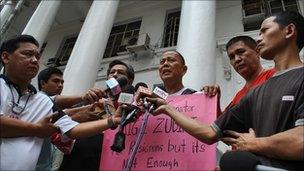 Father Robert Reyes speaks to the press