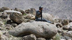 An Afghan policeman rests while patrolling with U.S. soldiers from Task Force Bronco, 3rd Squadron, 4th Cavalry, to search for arms cache, in a village in Nangarhar, Afghanistan September 8, 2011.