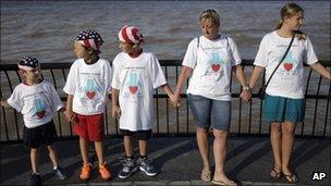 People join hands and observe a moment of silence during a remembrance of 9/11 in Lower Manhattan in New York, Saturday, Sept. 10, 2011