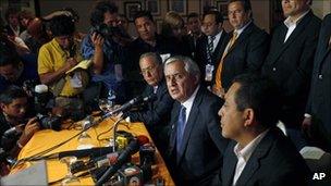 Otto Perez Molina (centre) talks to reporters on 12 September