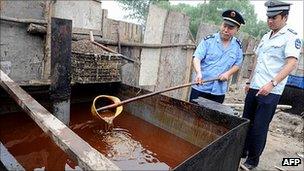 Police inspect illegal cooking oil seized during a crackdown in Beijing (August 2010)