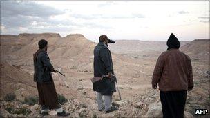 Libyan anti-government fighters stand on a mountain near Nalut on March 1, 2011