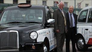 Grahame Lovett and Colin Russell next to the taxis