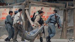 Afghan police carry a wounded colleague in Kabul (14 Sept 2011)