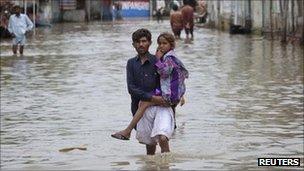 A man carries his sister in Pangrio, Sindh. Photo: 14 September 2011t