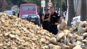 Kosovo police beside a barrier in Mitrovica