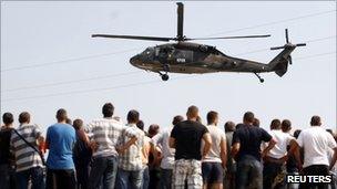 Ethnic Serbs watch a K-For helicopter take off near the Jarinje border crossing, 16 September