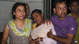 A woman, center who was injured in a building collapse that followed an earthquake is brought for treatment at a hospital in Siliguri, India, Sunday, Sept. 18, 2011