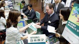 People wait in line at Hana bank in Seoul