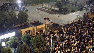 Chinese police (L) face villagers gathered in protest outside the gates to solar panel firm (17 September)