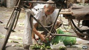 An elderly man scavenges discarded produce at a vegetable market in Beijing.