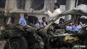 Security officials at the scene of the suicide bomb attack in Karachi on 19 September 2011