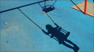 Shadow of a child on a park swing