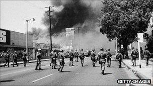 National guard troops run toward smoke in Watts, Los Angeles, 1965