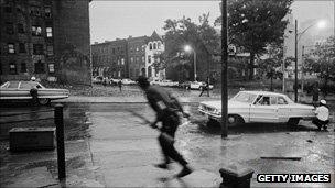 Police take cover behind parked cars in Newark in July, 1967