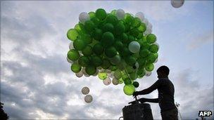 Boy releases green balloons into the sky