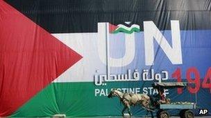 Horse cart passes a banner in Hebron supporting the Palestinian UN statehood bid