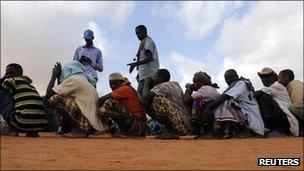 Workers count newly arrived Somali refugees, who wait in a line for the reception centre to open, at Ifo settlement at Kenya's Dadaab refugee Camp